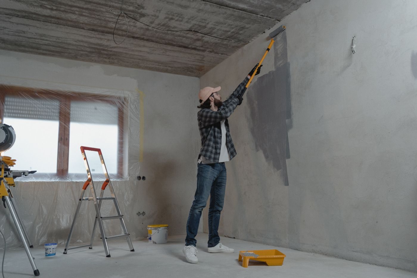 Painter rolling a wall on a bright job site
